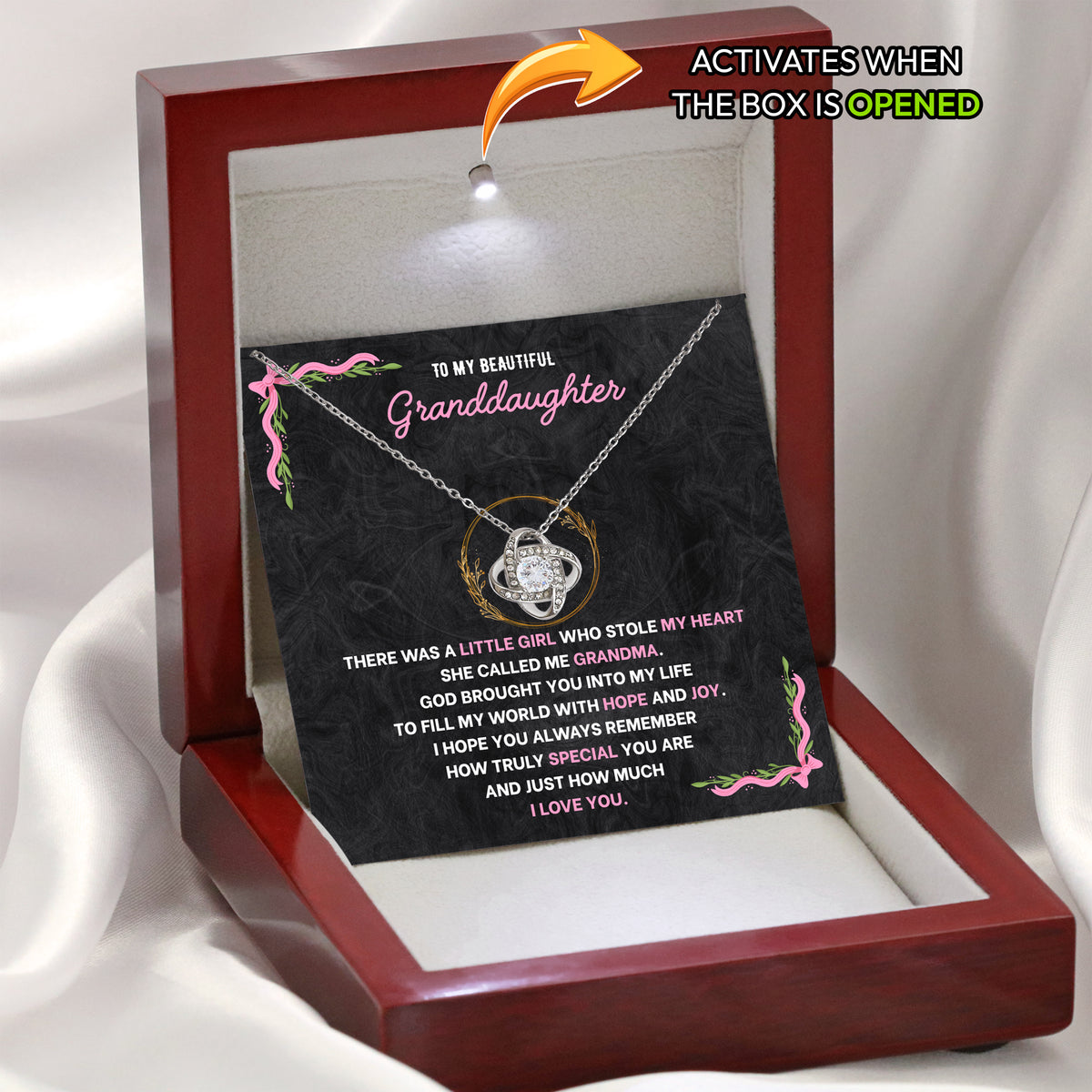 Open wooden gift box with a small light above a granddaughter necklace and its message card