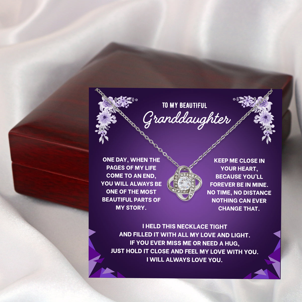 Hand holding an open wooden gift box with a granddaughter message card and necklace inside