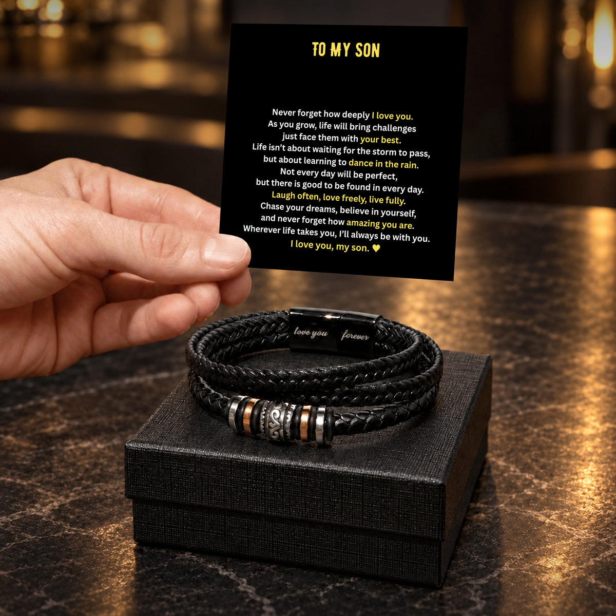 Close-up of the braided leather bracelet, engraved clasp and sliding metal rings on a dark rustic background