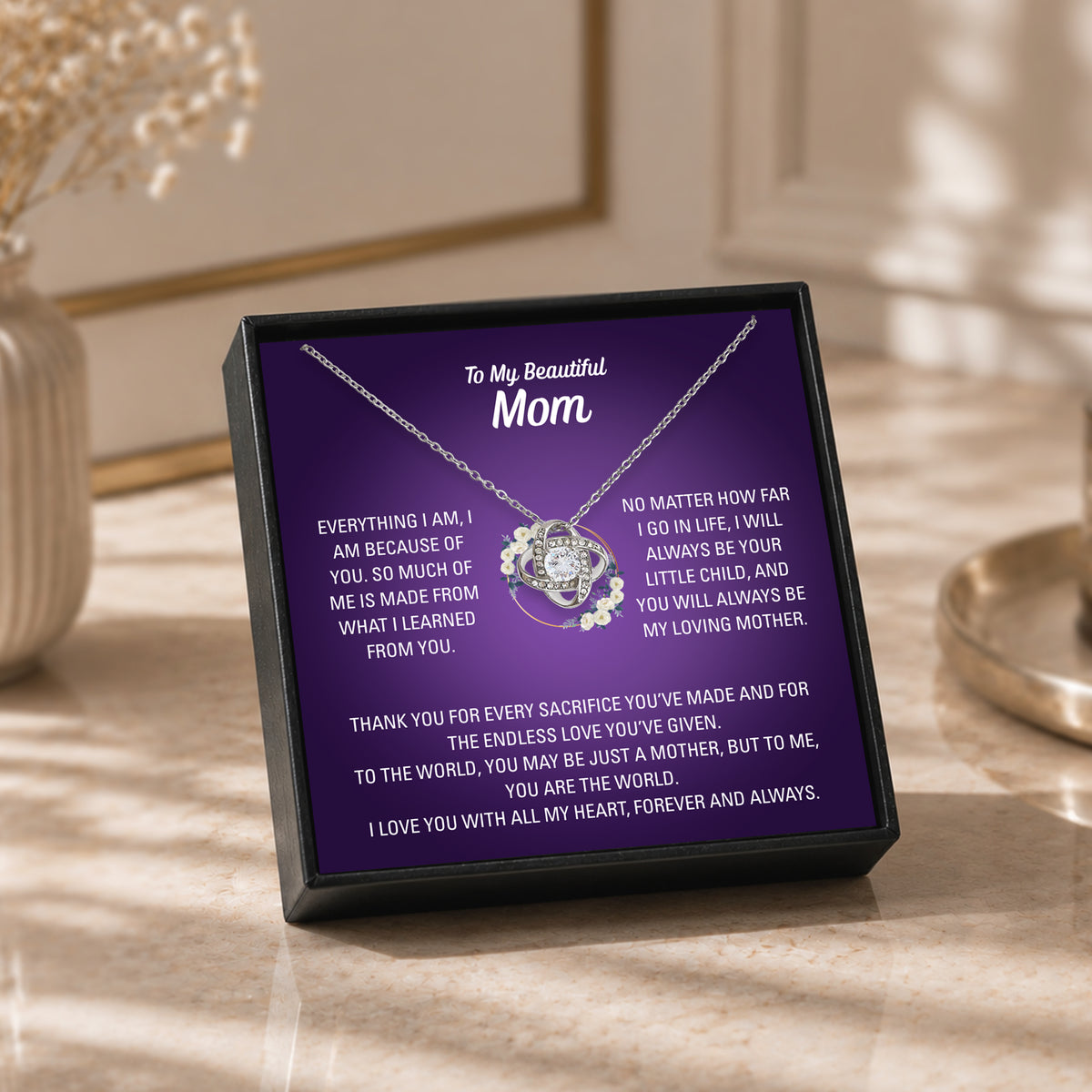 Gold-tone heart necklace and Mom message card shown with a wooden gift box and care cloth