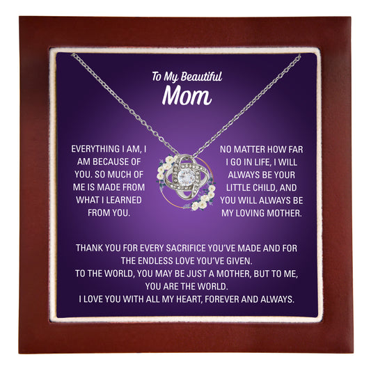 Silver heart necklace and To My Beautiful Mom message card against wooden jewellery box